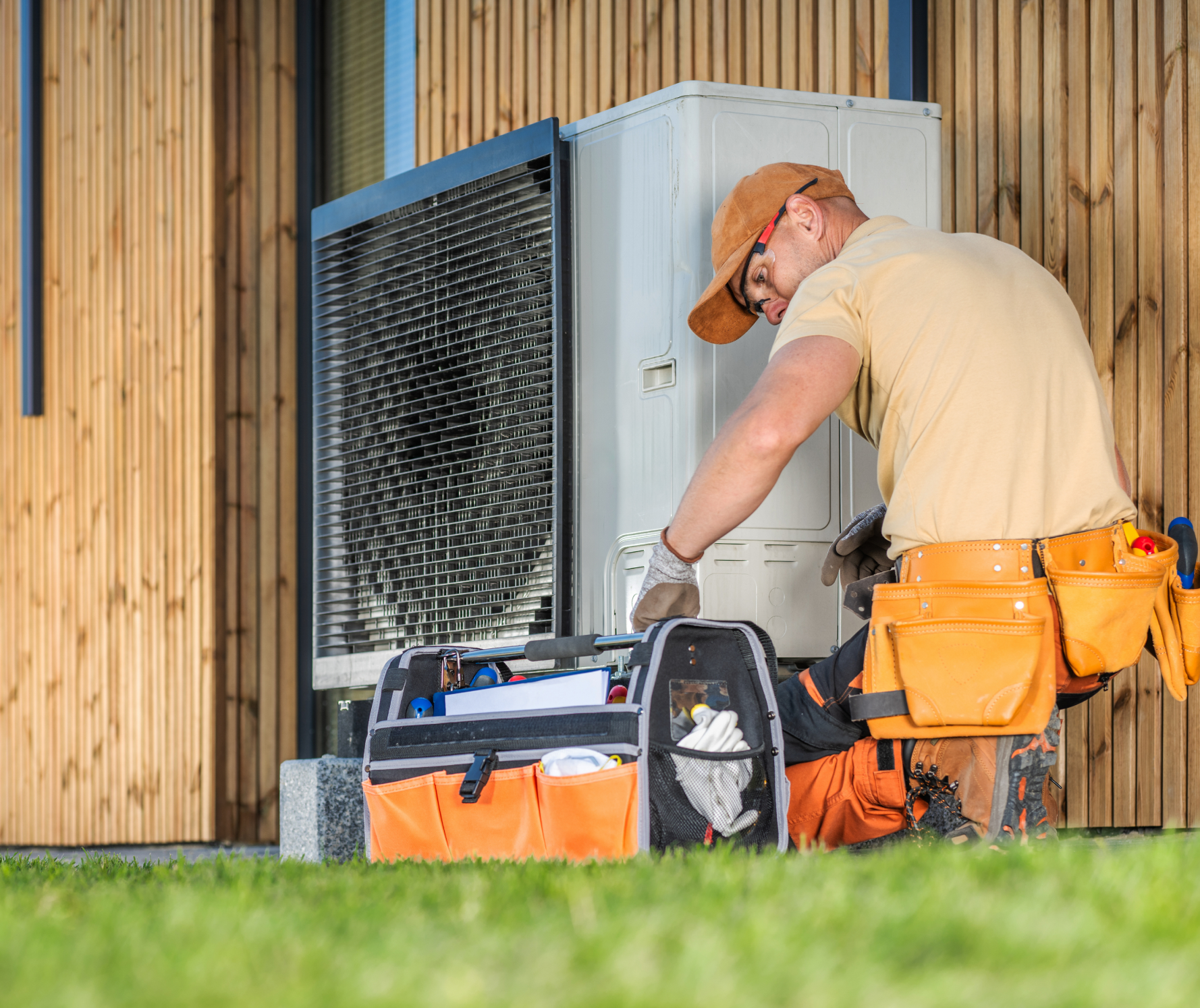 Technician repairing outdoor air conditioning unit.