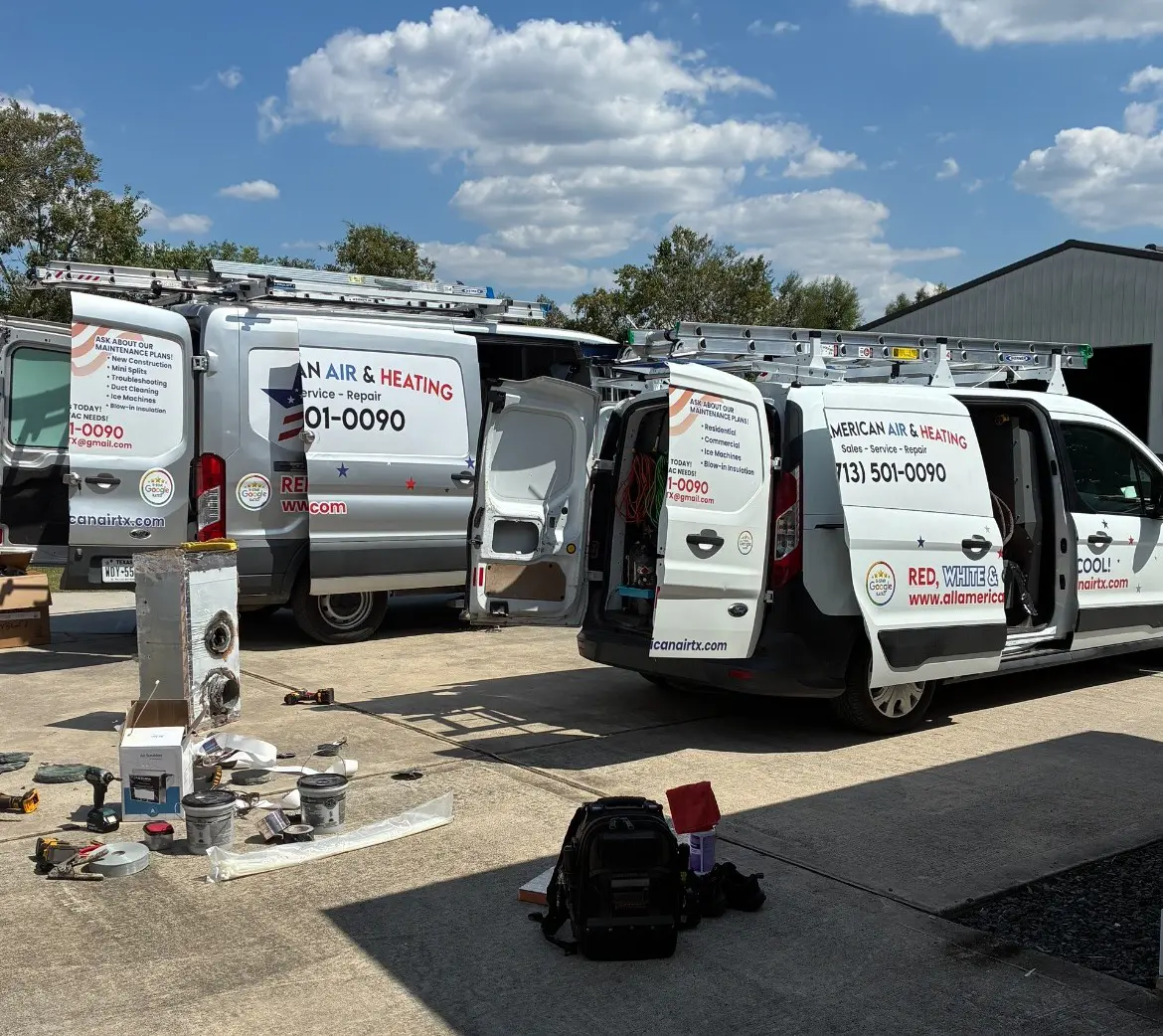 Multiple service vans parked outdoors under a blue sky with scattered clouds.