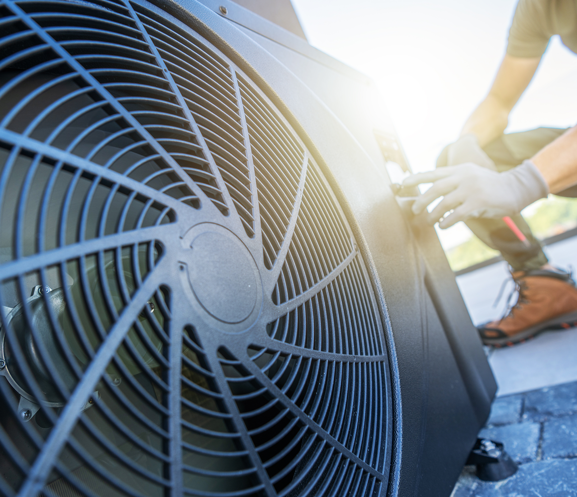 Technician working on outdoor air conditioning unit.