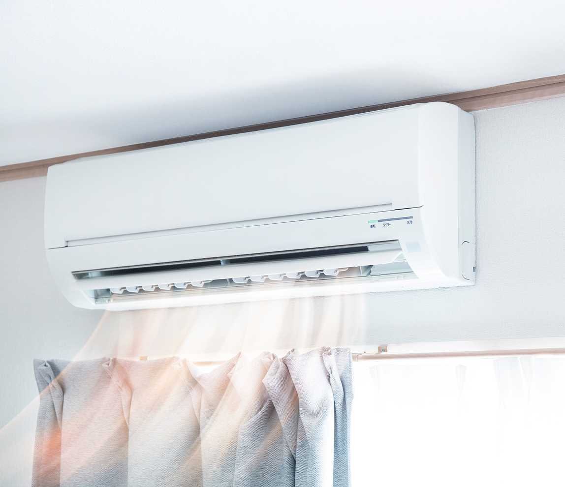 Wall-mounted air conditioner releasing cool air.